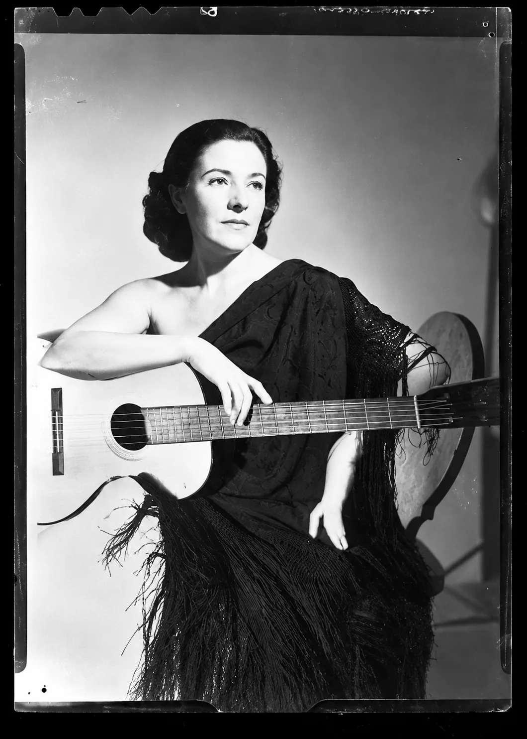 Recreación editorial asistida por IA inspirada en el retrato con guitarra de Imperio Argentina. No es la fotografía histórica original.